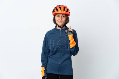 Téléchargez les photos : Jeune cycliste anglaise isolée sur fond blanc avec les doigts croisés et souhaitant le meilleur - en image libre de droit