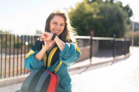 Foto de Joven mujer sosteniendo una mochila y sonriendo - Imagen libre de derechos