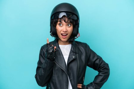 Téléchargez les photos : Jeune femme argentine avec un casque de moto isolé sur fond bleu pensant une idée pointant le doigt vers le haut - en image libre de droit
