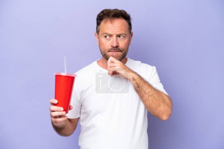 Photo for Middle age caucasian man holding soda isolated on purple background having doubts and thinking - Royalty Free Image