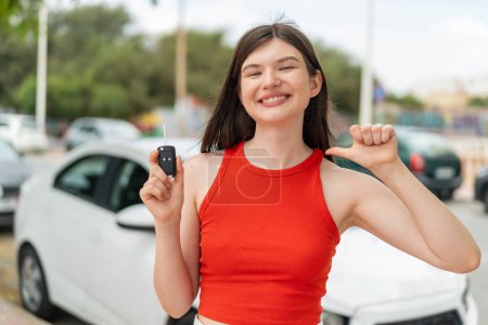 Téléchargez les photos : Jeune jolie femme ukrainienne tenant des clés de voiture à l'extérieur fier et satisfait de soi - en image libre de droit