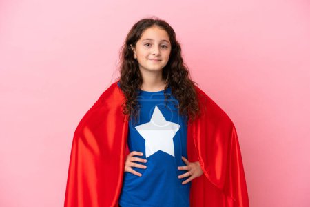 Photo for Little caucasian girl isolated on pink background in superhero costume posing with arms at hip and smiling - Royalty Free Image