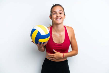 Téléchargez les photos : Jeune femme caucasienne jouant au volley isolé sur fond blanc souriant beaucoup - en image libre de droit