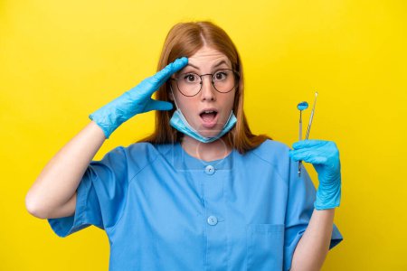 Téléchargez les photos : Jeune rousse Dentiste femme isolée sur fond jaune avec expression surprise - en image libre de droit