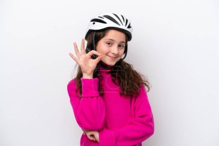 Foto de Niña ciclista aislada sobre fondo blanco mostrando signo de ok con los dedos - Imagen libre de derechos