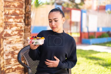Téléchargez les photos : Jeune fille marocaine tenant un bol de fruits à l'extérieur - en image libre de droit