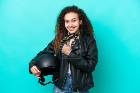 Photo for Young Arab woman with a motorcycle helmet isolated on blue background giving a thumbs up gesture - Royalty Free Image