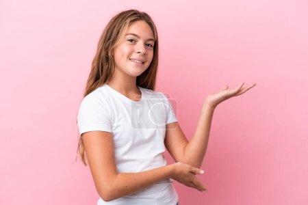Photo for Little caucasian girl isolated on pink background extending hands to the side for inviting to come - Royalty Free Image