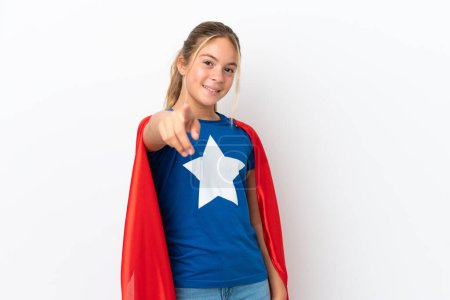 Téléchargez les photos : Petite fille caucasienne isolée sur fond blanc en costume de super-héros et pointant vers l'avant - en image libre de droit