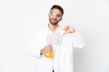 Téléchargez les photos : Jeune homme scientifique isolé sur fond blanc montrant pouce vers le bas avec une expression négative - en image libre de droit