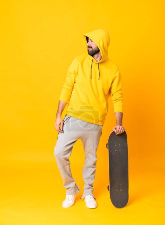 Photo for Full-length shot of a skater man over isolated yellow background - Royalty Free Image