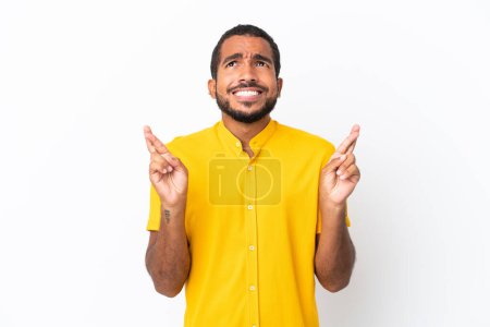 Photo for Young Ecuadorian man isolated on white background with fingers crossing and wishing the best - Royalty Free Image