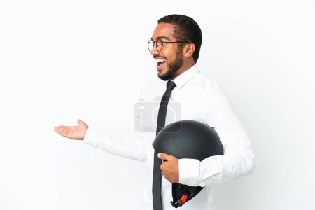 Foto de Joven hombre latino de negocios con un casco de moto aislado sobre fondo blanco con expresión sorpresa mientras mira al lado - Imagen libre de derechos