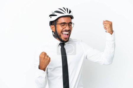 Foto de Joven hombre latino de negocios sosteniendo un casco de bicicleta aislado sobre fondo blanco celebrando una victoria - Imagen libre de derechos