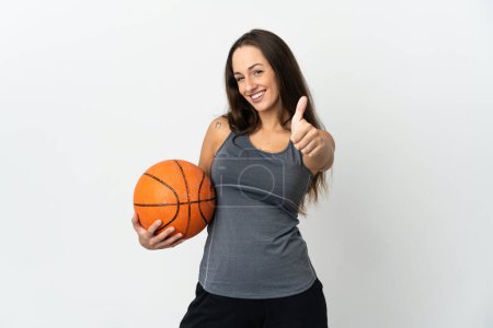 Téléchargez les photos : Jeune femme jouant au basket sur fond blanc isolé avec les pouces levés parce que quelque chose de bon est arrivé - en image libre de droit