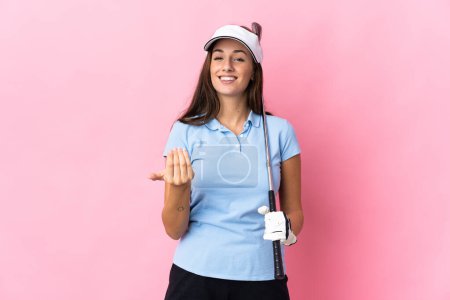 Photo for Young hispanic woman over isolated pink background playing golf and doing coming gesture - Royalty Free Image