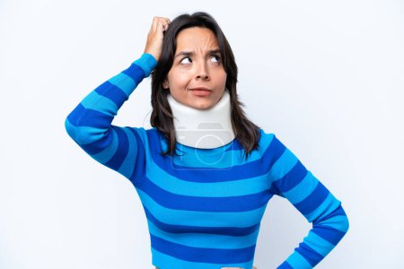 Photo for Young hispanic woman wearing neck brace isolated on white background having doubts and with confuse face expression - Royalty Free Image