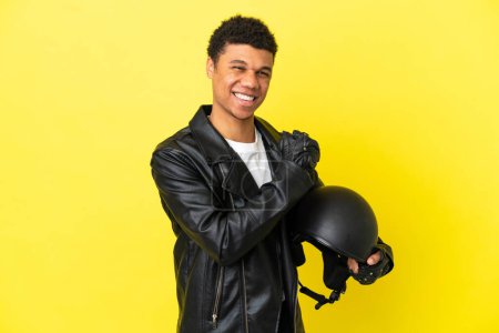 Téléchargez les photos : Jeune homme afro-américain avec un casque de moto isolé sur fond jaune célébrant une victoire - en image libre de droit