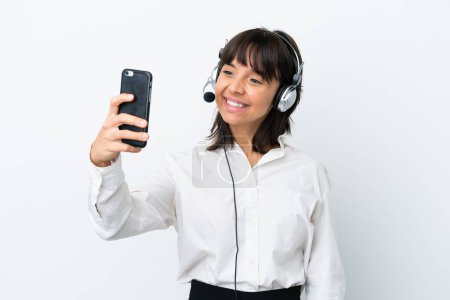 Photo for Telemarketer mixed race woman working with a headset isolated on white background making a selfie - Royalty Free Image