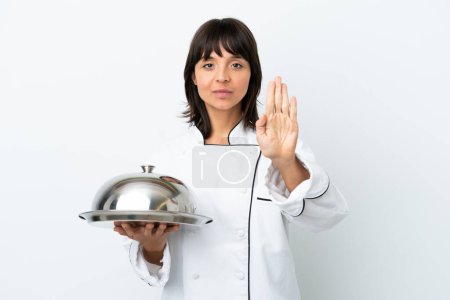 Foto de Joven chef con bandeja aislada sobre fondo blanco haciendo stop gesture - Imagen libre de derechos