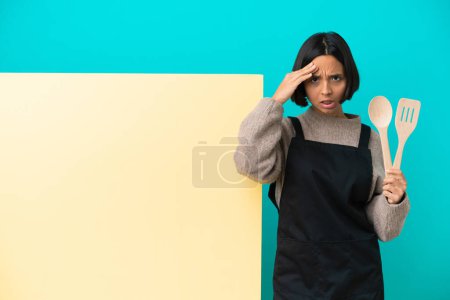 Téléchargez les photos : Jeune femme cuisinière mixte avec une grande plaque isolée sur fond bleu a réalisé quelque chose et l'intention de la solution - en image libre de droit