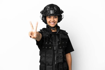 Téléchargez les photos : SWAT femme isolée sur fond blanc souriant et montrant signe de victoire - en image libre de droit