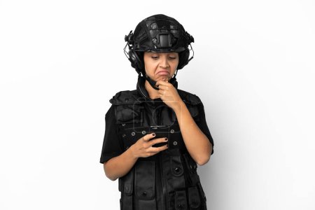 Foto de Mujer SWAT aislada sobre fondo blanco pensando y enviando un mensaje - Imagen libre de derechos