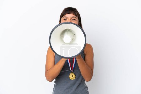 Photo for Young mixed race woman with medals isolated on white background shouting through a megaphone - Royalty Free Image