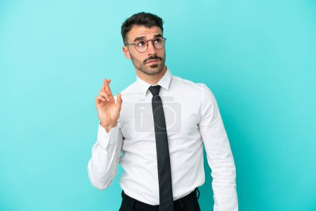 Photo for Business caucasian man isolated on blue background with fingers crossing and wishing the best - Royalty Free Image