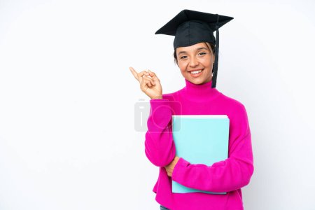 Téléchargez les photos : Jeune étudiante hispanique femme tenant un livre isolé sur fond blanc pointant du doigt vers le côté - en image libre de droit