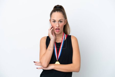 Foto de Mujer joven caucásica con medallas aisladas sobre fondo blanco sorprendida y sorprendida mientras mira a la derecha - Imagen libre de derechos