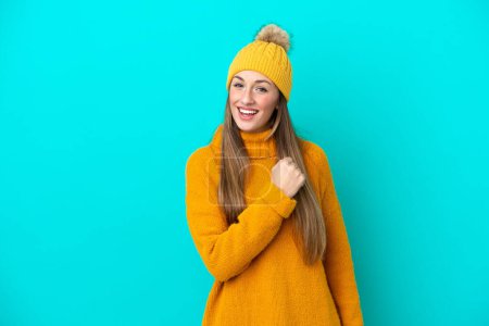 Téléchargez les photos : Jeune femme caucasienne portant une veste d'hiver isolée sur fond bleu célébrant une victoire - en image libre de droit