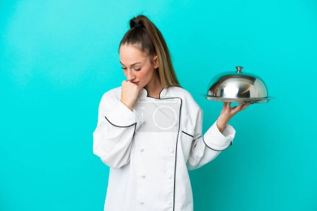 Photo for Young caucasian chef woman with tray isolated on blue background having doubts - Royalty Free Image