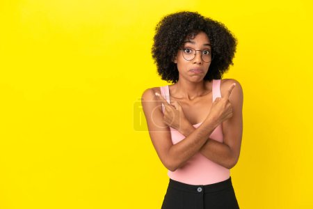 Photo for Young African American woman isolated on yellow background pointing to the laterals having doubts - Royalty Free Image