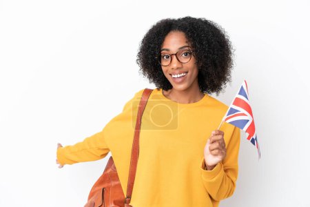 Téléchargez les photos : Jeune femme afro-américaine tenant un drapeau du Royaume-Uni isolé sur fond blanc étendant les mains sur le côté pour inviter à venir - en image libre de droit