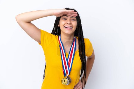 Photo for Teenager girl with braids and medals over isolated pink background looking far away with hand to look something - Royalty Free Image