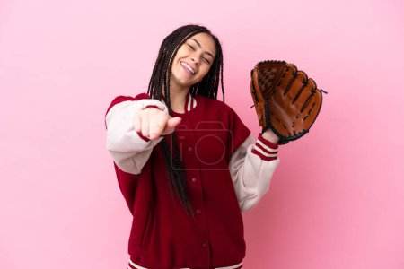 Foto de Jugador adolescente con guante de béisbol aislado sobre fondo rosa apuntando frente con expresión feliz - Imagen libre de derechos