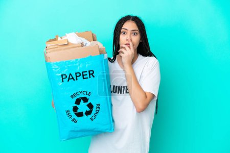 Photo for Teenager girl with braids holding a bag to recycle surprised and shocked while looking right - Royalty Free Image