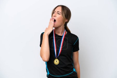 Photo for Young caucasian woman with medals isolated on white background yawning and covering wide open mouth with hand - Royalty Free Image
