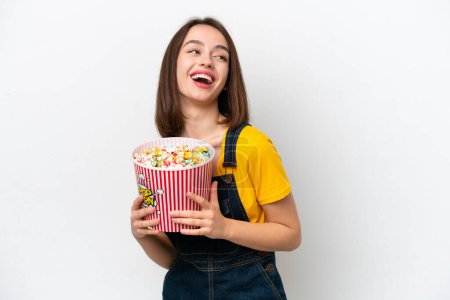 Foto de Young Ukrainian woman isolated on white background holding a big bucket of popcorns - Imagen libre de derechos