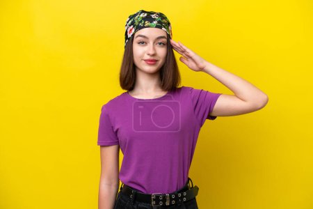 Photo for Young Ukrainian woman isolated on yellow background saluting with hand with happy expression - Royalty Free Image