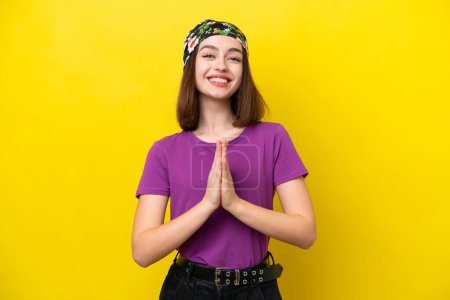 Photo for Young Ukrainian woman isolated on yellow background keeps palm together. Person asks for something - Royalty Free Image