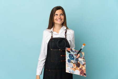 Téléchargez les photos : Jeune artiste slovaque femme isolée sur fond bleu penser une idée tout en levant les yeux - en image libre de droit
