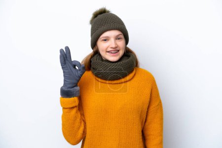 Photo for Teenager Russian girl wearing winter jacket isolated on white background showing ok sign with fingers - Royalty Free Image