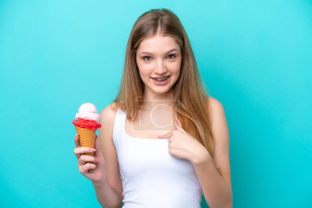 Foto de Adolescente chica rusa con un helado de corneta aislado sobre fondo azul con expresión facial sorpresa - Imagen libre de derechos