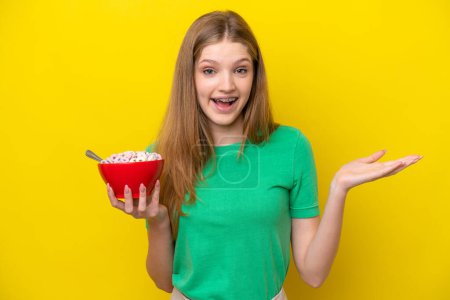 Photo for Teenager Russian girl holding bowl of cereals isolated on yellow background with shocked facial expression - Royalty Free Image