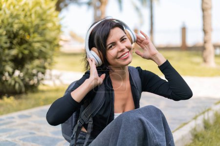 Téléchargez les photos : Jeune jolie femme bulgare à l'extérieur écouter de la musique - en image libre de droit