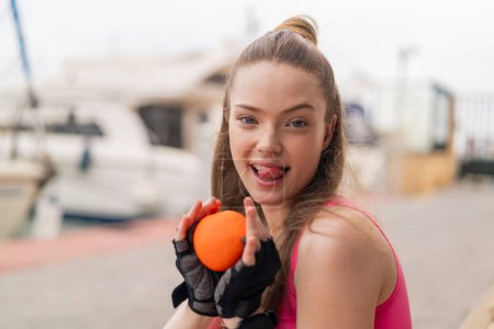 Foto de Joven chica bonita deporte al aire libre sosteniendo una naranja con expresión feliz - Imagen libre de derechos