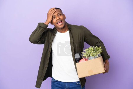 Photo for Latin man making a move while picking up a box full of things smiling a lot - Royalty Free Image
