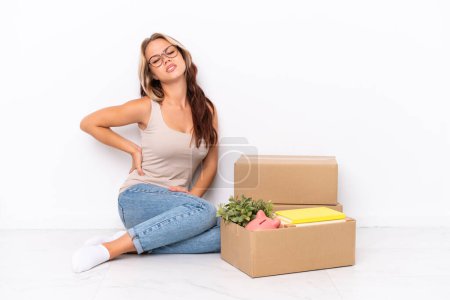 Photo for Young Russian girl sitting on the floor isolated on white background suffering from backache for having made an effort - Royalty Free Image